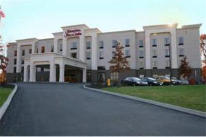 un gran edificio blanco con coches estacionados frente a él en Hampton Inn and Suites Jamestown, en Jamestown