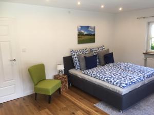 1 dormitorio con 1 cama y 1 silla verde en Ferienwohnung Laurin en Garmisch-Partenkirchen