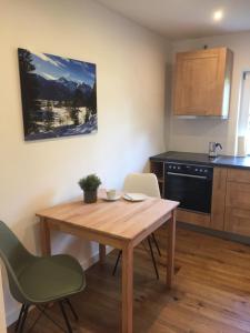 een kleine keuken met een houten tafel en stoelen bij Ferienwohnung Laurin in Garmisch-Partenkirchen