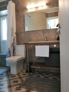 een badkamer met een toilet, een wastafel en een spiegel bij 1920 in Finikounta +13 foto's