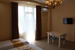 Nakashidze's Apartments في باتومي: غرفة فندقية بطاولة وسرير ونافذة