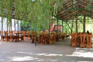 eine Gruppe von Holztischen und -stühlen in einem Pavillon in der Unterkunft Fortetsya in Uman