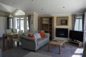 een woonkamer met een bank en een televisie bij Lodge 77 in St Austell