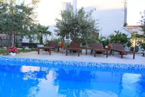 a group of chairs sitting next to a swimming pool at Villa Maria in Split
