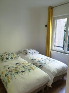 2 Betten in einem Zimmer mit Fenster in der Unterkunft Appartement La Vue Sur Mer in Boulogne-sur-Mer