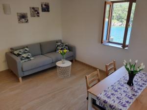 a living room with a couch and a table at Apartments Stella Apsyrtides in Osor
