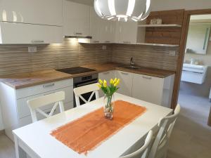 una cocina con una mesa con un jarrón de flores. en Apartments Stella Apsyrtides en Osor