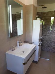 a bathroom with a white sink and a mirror at Apartments Stella Apsyrtides in Osor +70 photos
