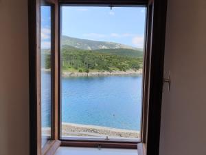 a window with a view of a body of water at Apartments Stella Apsyrtides in Osor