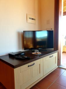 a large flat screen tv sitting on top of a cabinet at Residence Ataras in Porto San Paolo