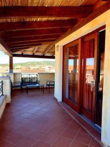 un porche de una casa con puerta de cristal en Residence Ataras, en Porto San Paolo