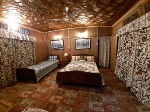 heritage geneva house boat في سريناغار: غرفة نوم بسريرين في غرفة ذات سقف