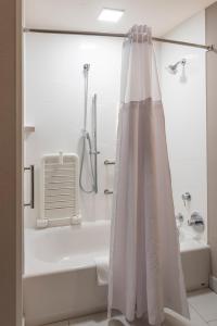 a bathroom with a shower and a tub and a shower curtain at Wingate by Wyndham Angola in Angola