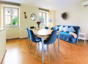 a dining room with a table and blue chairs at House Julija in Piran