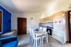 een keuken met een tafel en stoelen in een kamer bij Residence Le Ginestre / Ataras in Porto San Paolo