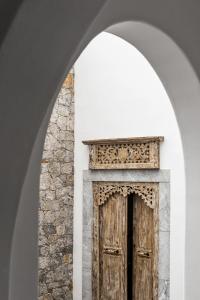 an archway with a wooden door in a stone wall at Saluti Da Stampalia in Astypalaia Town