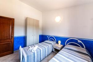 twee bedden in een kamer met blauwe en witte muren bij Residence Le Ginestre / Ataras in Porto San Paolo