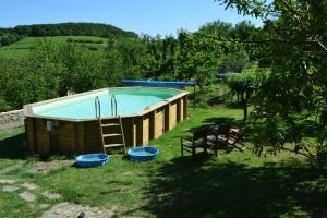 a pool in a yard with two chairs and a ladder at La Follye Mancey in Mancey