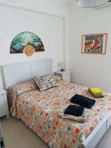een slaapkamer met een bed met een dekbed erop bij Appartamento Betty in Porto Santo Stefano