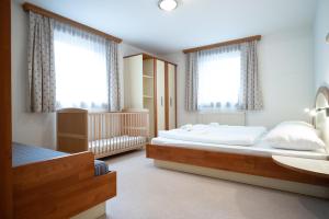 sypialnia z dużym łóżkiem i dwoma oknami w obiekcie Seilergasse Apartments by we rent, SUMMERCARD INCLUDED w mieście Zell am See