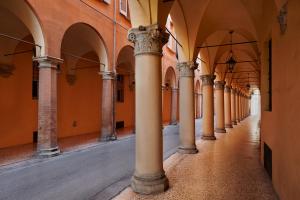 Une allée avec des colonnes dans un ancien bâtiment dans l'établissement San Giorgio 2, à Bologne