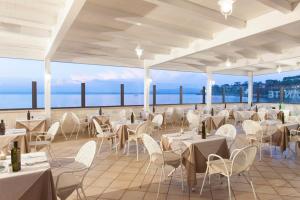 um restaurante com mesas e cadeiras e vista para o oceano em Baia D'Argento em Porto Santo Stefano