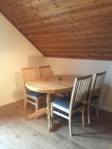 a wooden table with two chairs and a wooden ceiling at Anexet in Kungsbacka