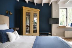 a bedroom with blue walls and a large bed at Bed and Breakfast Het Dijkhuis Eersel in Eersel