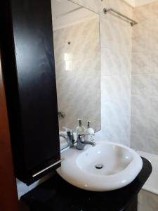 a bathroom with a white sink and a mirror at Mirina View Apartment in Myrina