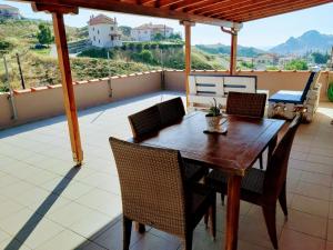 a wooden table and chairs on a balcony at Mirina View Apartment in Myrina