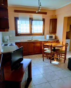 a kitchen with a table and chairs and a microwave at Mirina View Apartment in Myrina