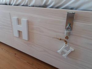 a sign with the letter h on top of a bed at Origens Hostel in Sines