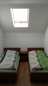 two twin beds in a room with a window at Argo Domki in Darłowo