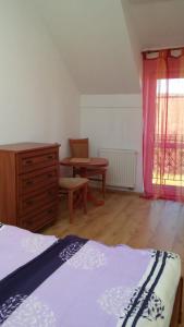 um quarto com uma cama, uma cómoda e uma janela em Argo Domki em Darłowo
