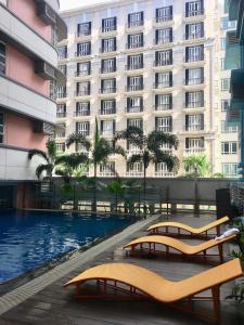 un hôtel avec une piscine devant un bâtiment dans l'établissement 101 Newport Boulevard C1, à Manille