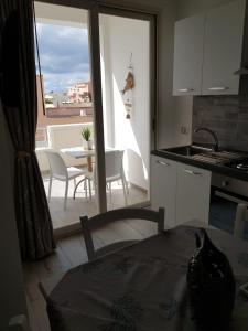 a kitchen with a table and chairs and a kitchen with a window at Appartamenti Edia in Lampedusa