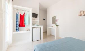 a white room with a bed and a mirror at Anita Rooms & Apartments in Adamantas