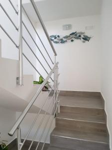 a staircase in a house with white walls and wooden floors at Appartamenti Edia in Lampedusa