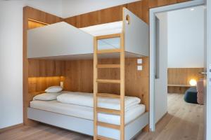 Etagenbett in einem kleinen Zimmer mit einer Leiter in der Unterkunft Appartement Hell in Toblach