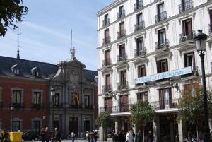 ein großes weißes Gebäude mit einem Straßenschild drauf in der Unterkunft Hostal La Perla Asturiana in Madrid