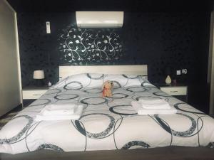 Un dormitorio con una cama grande con un animal de peluche. en Guest house Grahlyov en Sapareva Banya