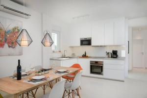 uma cozinha branca com uma mesa de madeira e cadeiras em HOLIDAY HOME VENTUM em Sibenik