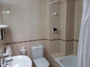 a bathroom with a toilet and a sink and a tub at Hostal Mary in Lloret de Mar