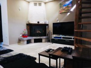 a living room with a fireplace and a tv at Guest house Grahlyov in Sapareva Banya
