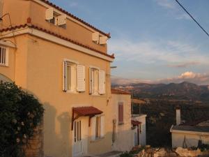 ein Gebäude mit weißen Fensterläden und einer Aussicht in der Unterkunft SAMOS 1880 in Marathokampos