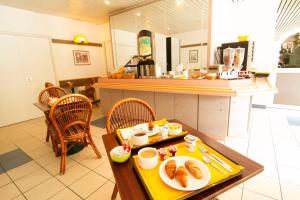 een cafetaria met een tafel met eten erop bij EGG HOTEL - HOTEL LES GENS DE MER Dieppe in Dieppe