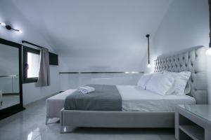 a white bedroom with a large bed and a window at Anemos Luxury Apartments in Ayios Nikolaos Sithonia