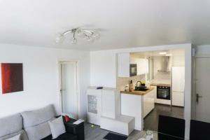 a living room with a couch and a kitchen at Precioso apartamento en la playa Barcelona in Cabrera de Mar