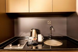 a kitchen counter with a coffee maker and a sink at A Palace Suites in Istanbul