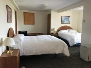 a hotel room with two beds and a desk at Hopewell Rocks Motel & Country Inn in Hopewell Cape